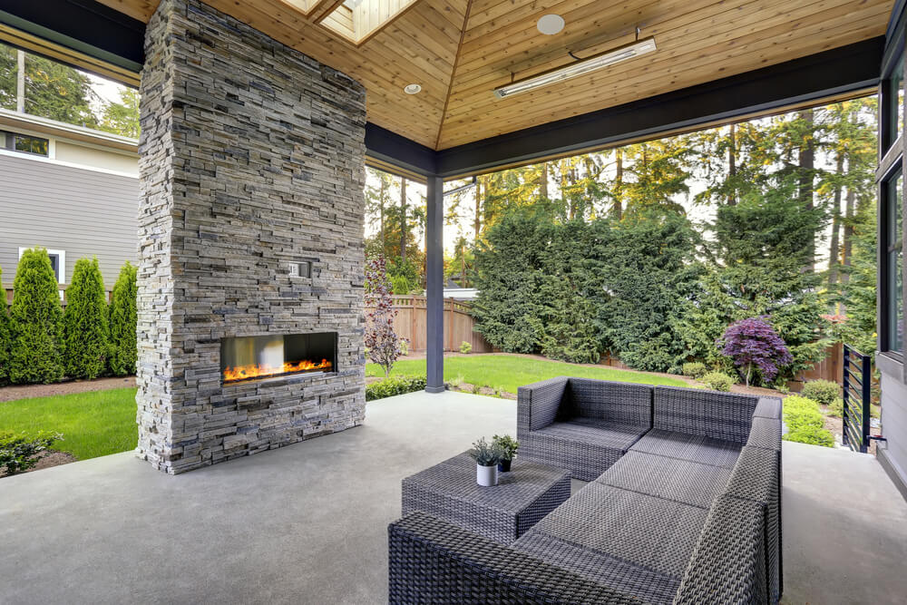 Backyard With Covered Patio Accented With Stone Fireplace