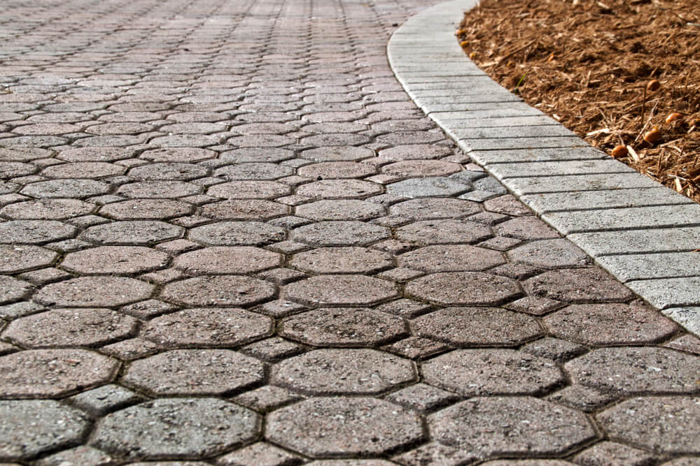 Low Angle View of Octagon and Square Shaped Brick Pavers With Curved Section of Driveway With Rectangle Bricks Along Edge.