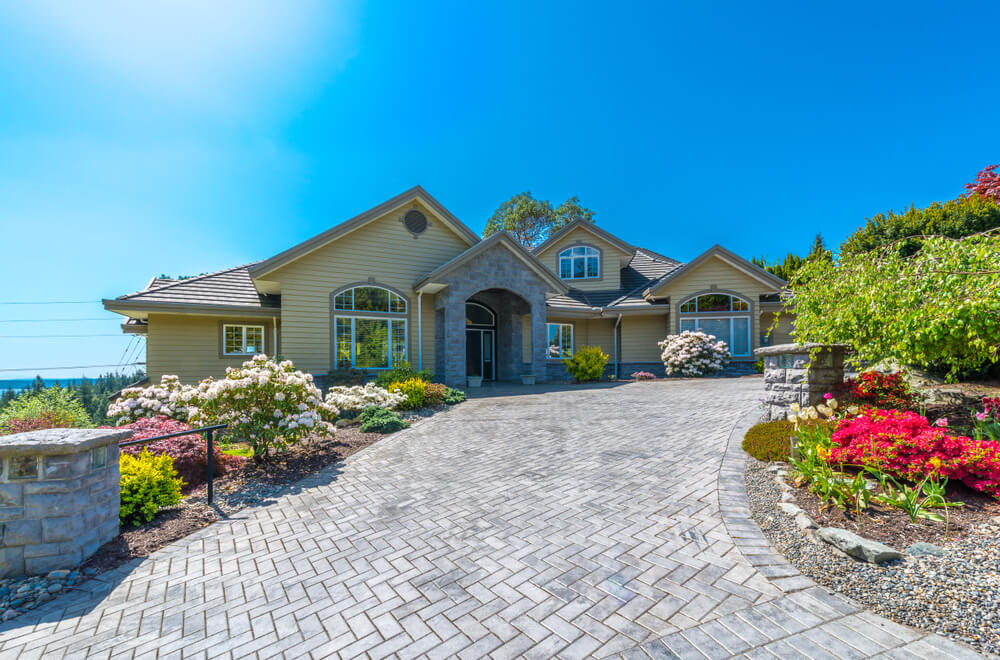 luxury house with nicely landscaped and trimmed front yard and driveway to garage in the suburbs