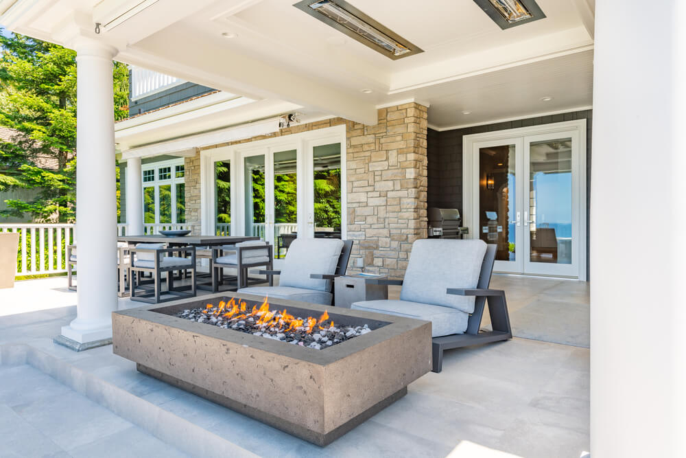 Luxury home patio with a fireplace and patio furniture.